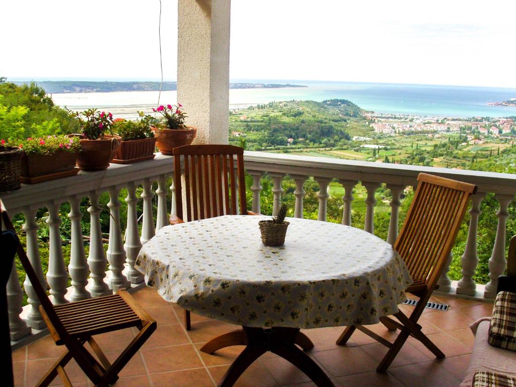 a table and chairs on a balcony with a view of the ocean at Apartments Rosemary in Lucija