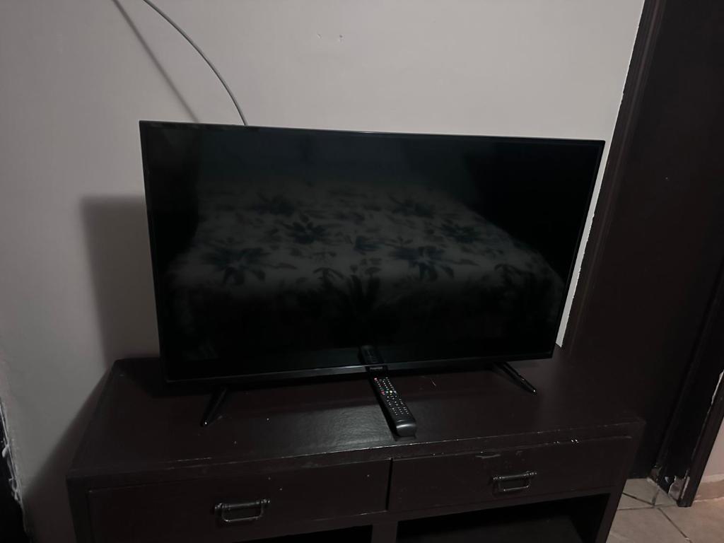 a television sitting on a dresser with a remote control at Condominio 1 in San Felipe