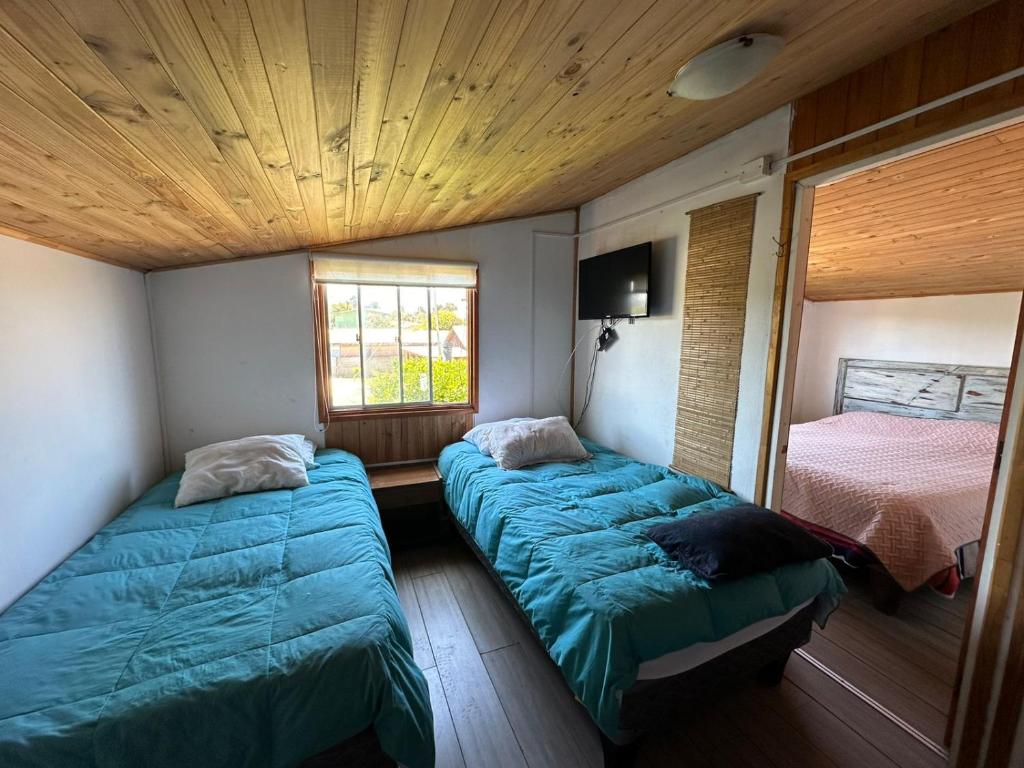 Una cama o camas en una habitación de Cabañas Sal y Arena El Quisco Norte