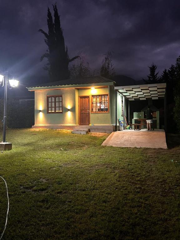 a small house at night with the lights on at Cabañas Villa Alicia in Potrerillos