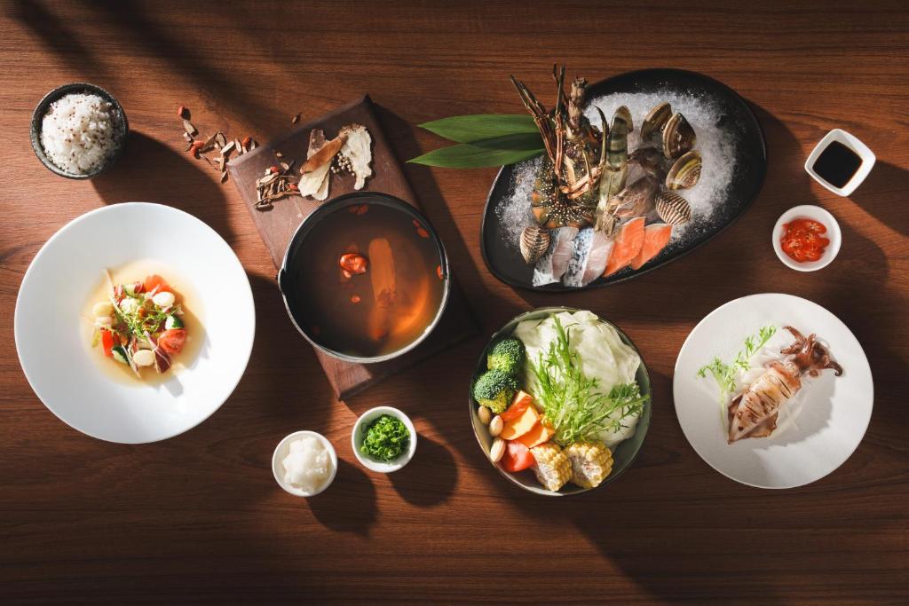 a wooden table with plates of food on it at Adagio Shihtiping in Fengbin