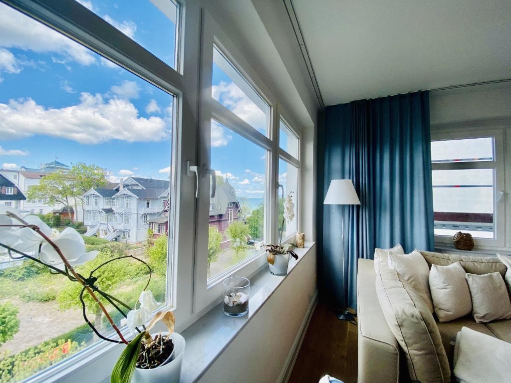 ein Wohnzimmer mit Couch und großem Fenster in der Unterkunft Ferienwohnung Binzer Seeblick Haus Jahreszeiten Binz in Binz