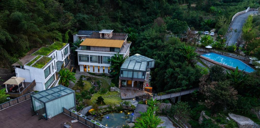 张家界Zhangjiajie Rock language art hotel-Free pick up service的享有房子和游泳池的空中景致