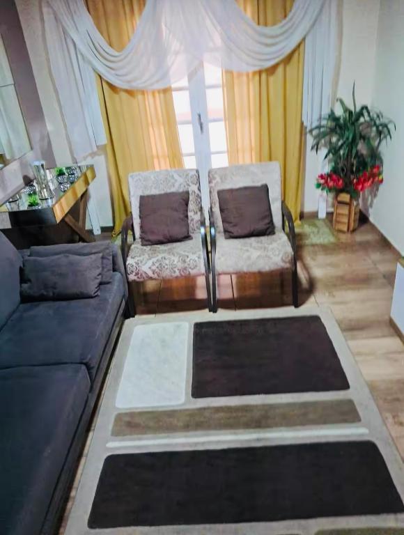 a living room with a couch and a chair at Della Giustina Residence Comforto Aparthotel - Aconchegante, Lindo, Moderno, Renovado entre Abba Pai Church e Centro in Criciúma