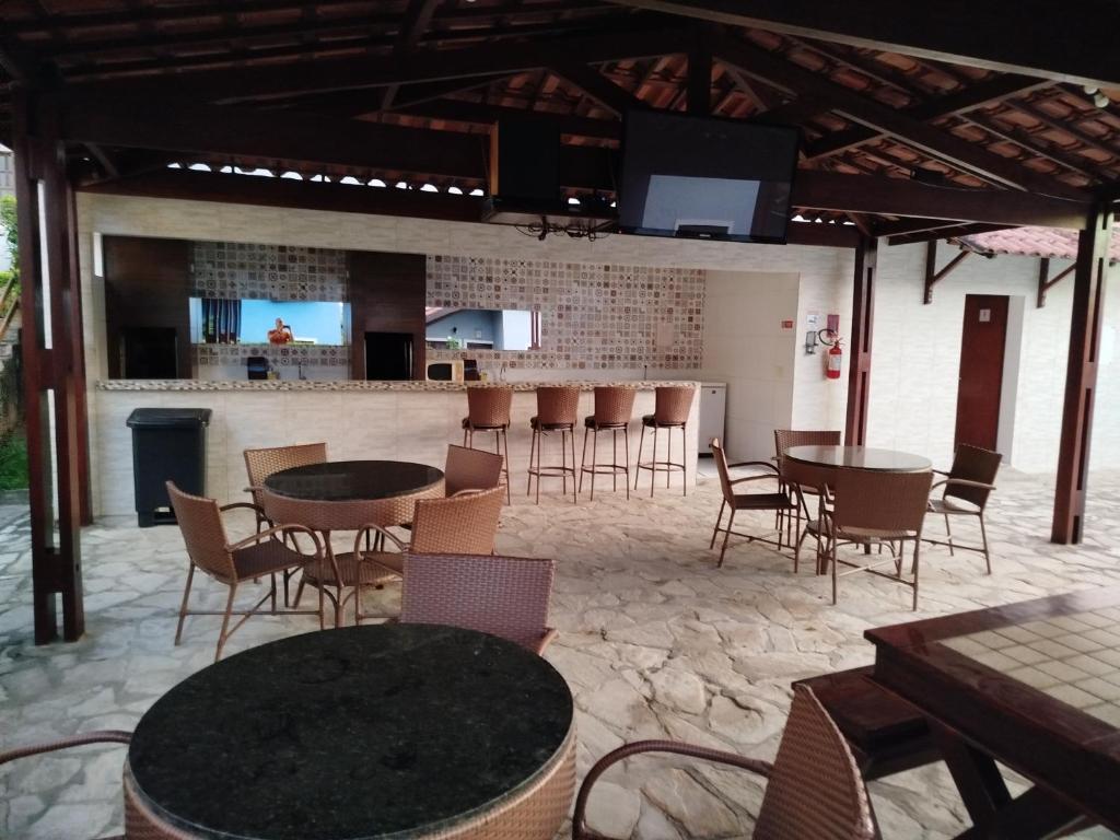 a patio with tables and chairs and a bar at Linda casa de veraneio em Gravatá in Gravatá