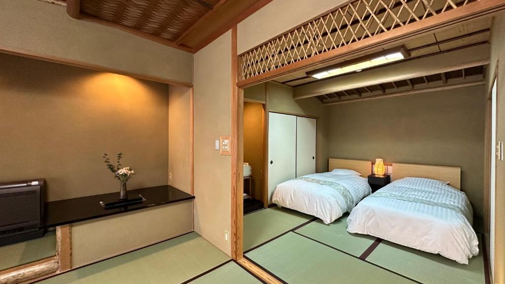 Postel nebo postele na pokoji v ubytování Ryoutei Ryokan Takechiyo Kirishima Bettei