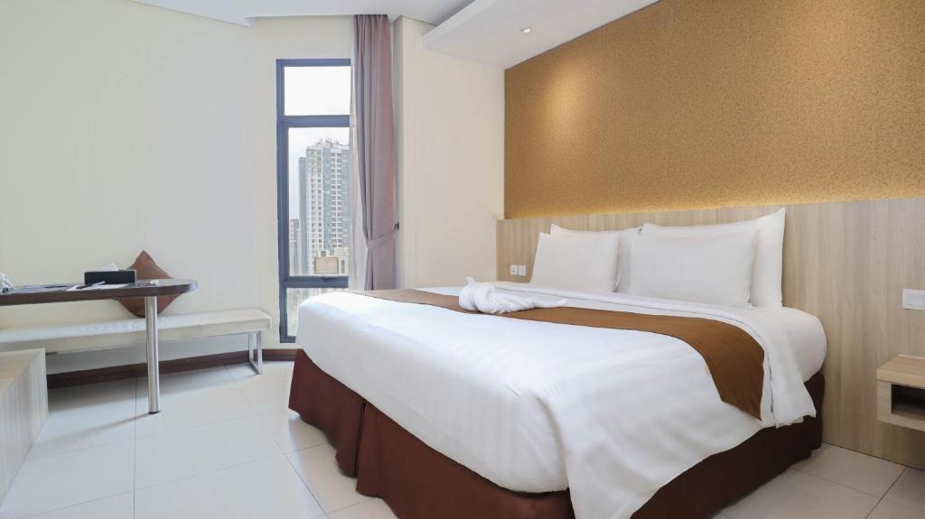 Postel nebo postele na pokoji v ubytování Vasaka Hotel Jakarta Managed by Dafam