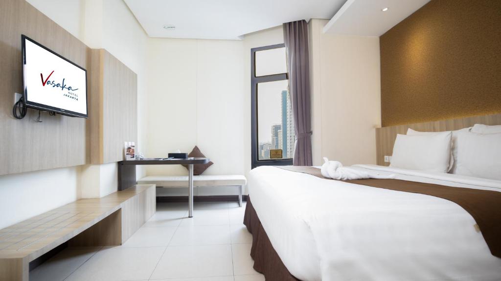Postel nebo postele na pokoji v ubytování Vasaka Hotel Jakarta Managed by Dafam