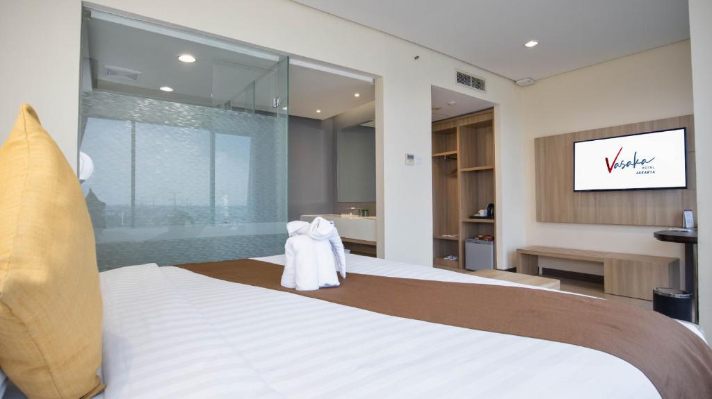 Postel nebo postele na pokoji v ubytování Vasaka Hotel Jakarta Managed by Dafam