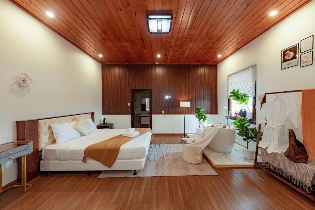 a bedroom with a large bed and a wooden ceiling at Biệt Thự Đà Lạt Nghỉ Dưỡng Gia Đình in Trai Mat