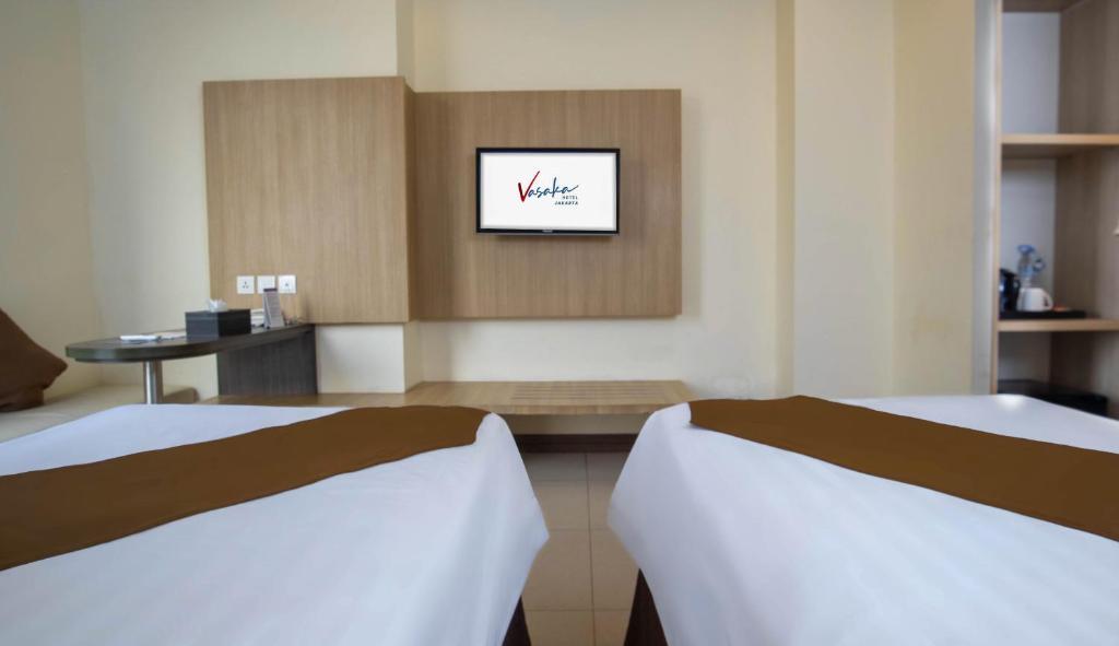 Postel nebo postele na pokoji v ubytování Vasaka Hotel Jakarta Managed by Dafam