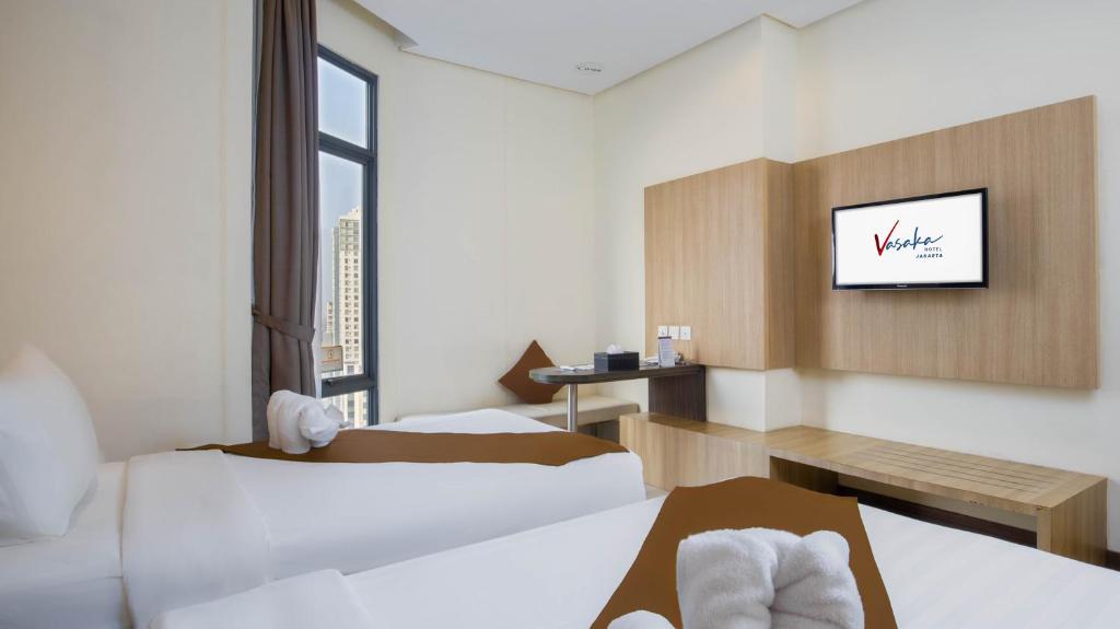 Postel nebo postele na pokoji v ubytování Vasaka Hotel Jakarta Managed by Dafam