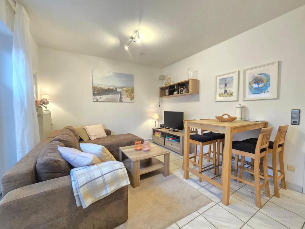 a living room with a couch and a table at Ferienwohnung Ebbe in Dornum