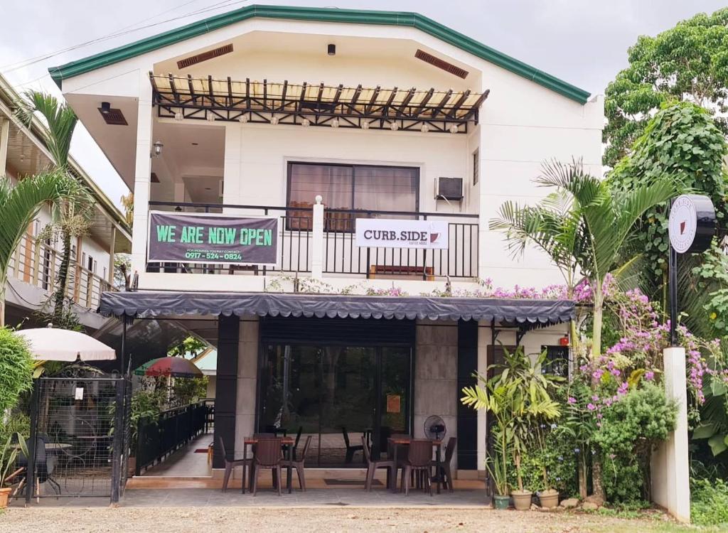 a building with a balcony with tables and chairs at Roccksar Pension House in Puerto Princesa City