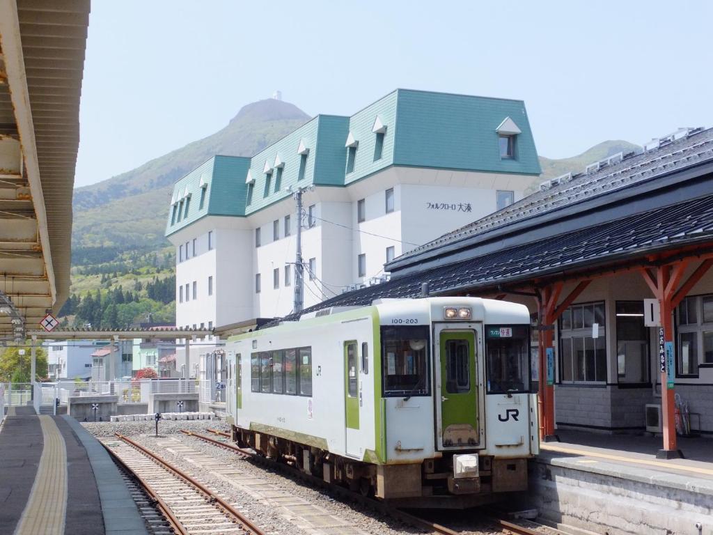 un tren en las vías de una estación de tren en Hotel Folkloro Ominato en Mutsu