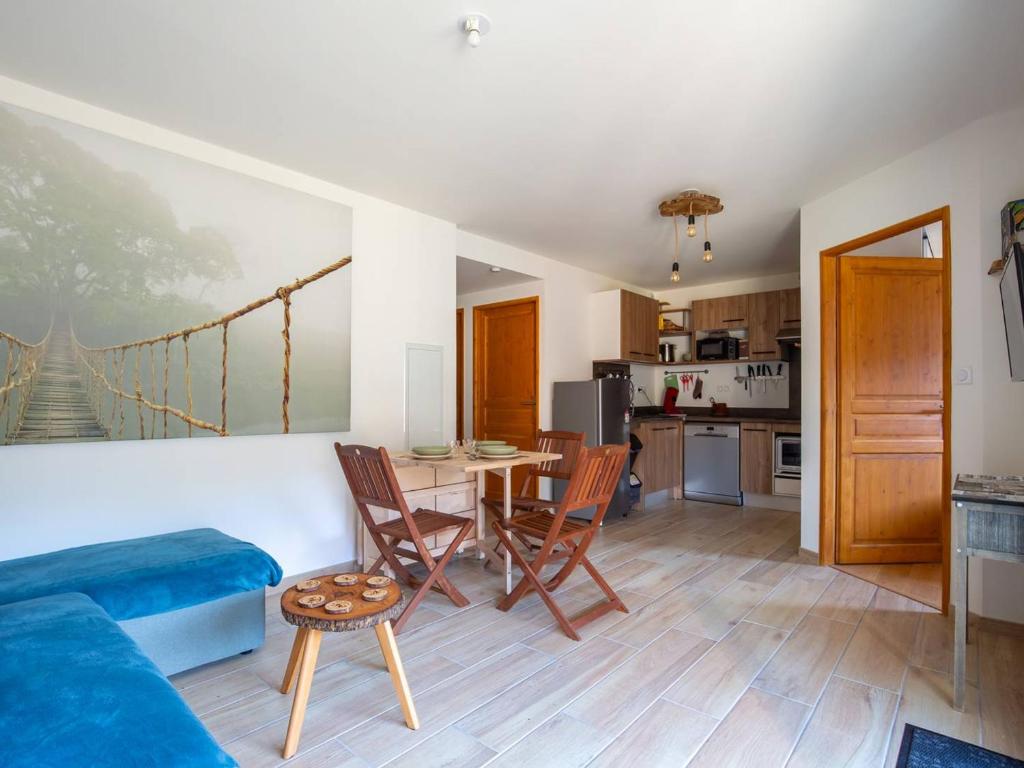 a kitchen and a living room with a table and chairs at Appartement moderne 4 pers, proche SkyVall, parking gratuit - FR-1-695-63 in Loudenvielle