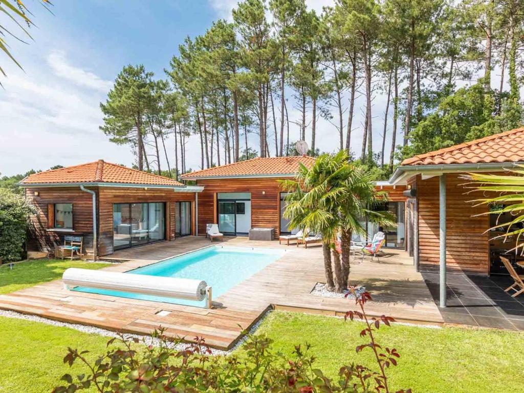 une maison avec une piscine dans une cour dans l'établissement Villa d'exception pour 10 pers avec piscine chauffée et parking privé à Labenne - FR-1-791-28, à Labenne