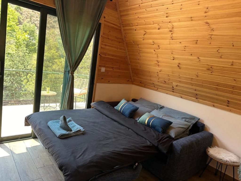 a bedroom with a large bed in a room with windows at Cozy Glamping Cabin for Couples and Families in Arakapas