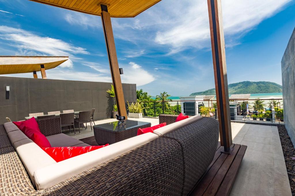 an outdoor patio with a couch and a table at Mojito Residence Phuket in Rawai Beach