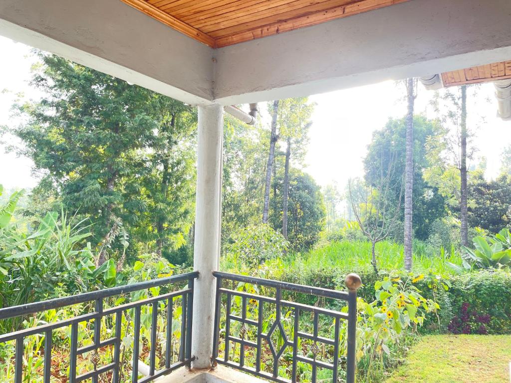 a screened in porch with a view of a garden at Aberdare Home in Othaya