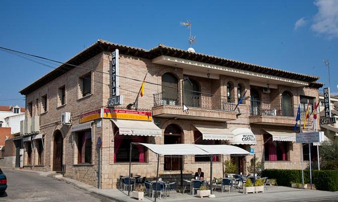 een gebouw met tafels en stoelen ervoor bij Hostal Castilla in Mocejón