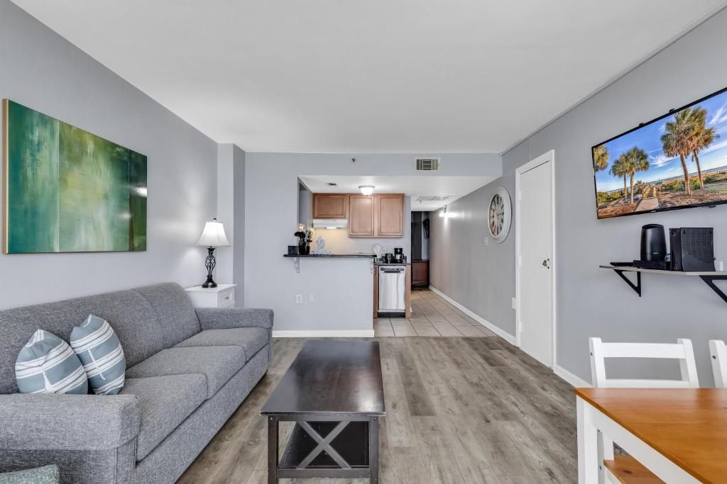 a living room with a couch and a kitchen at Oceanfront Condo at Meridian Plaza in Myrtle Beach