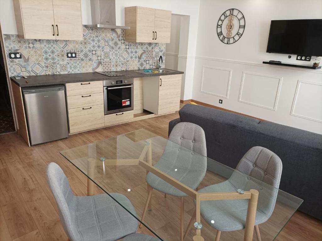 un salon avec une table en verre et des chaises dans l'établissement T2 viel Antibes hyper centre, à Antibes