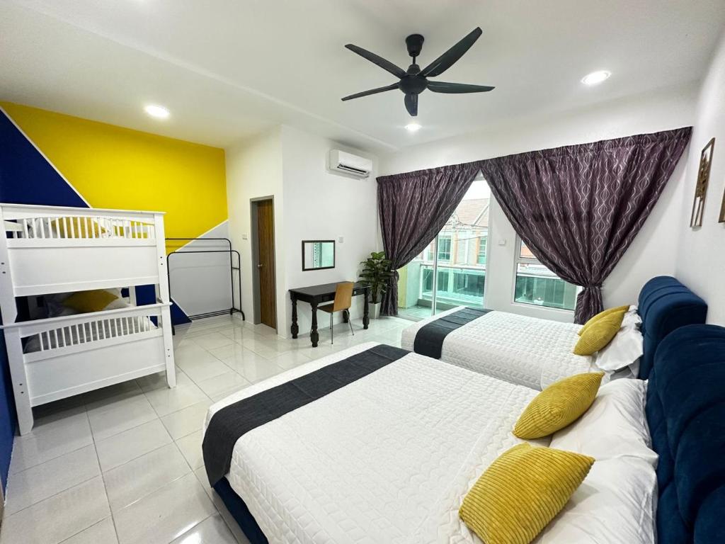 a bedroom with two beds and a ceiling fan at La Mensa Families Cheerful Residences in Ulu Melaka