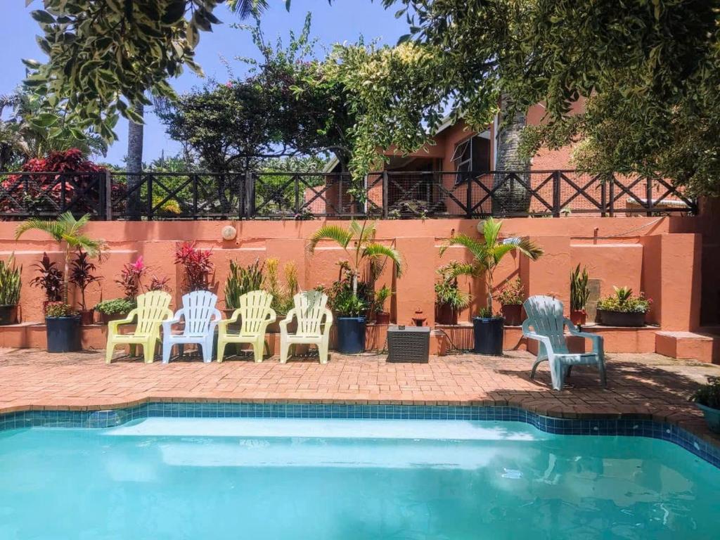 a patio with chairs and a swimming pool at Indigo Chalets in Port Edward