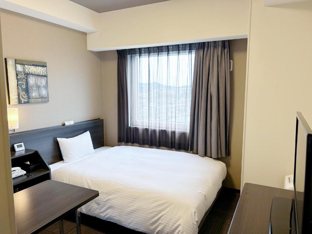 Postel nebo postele na pokoji v ubytování Hotel Route Inn Isehara Ooyama Inter -Kokudo 246 Gou-