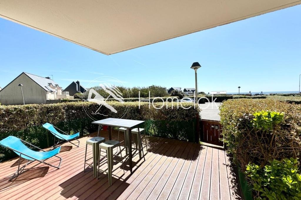 un patio avec deux chaises et une table sur une terrasse dans l'établissement Joli appartement cosy Terrasse face à la mer, à Ploemeur