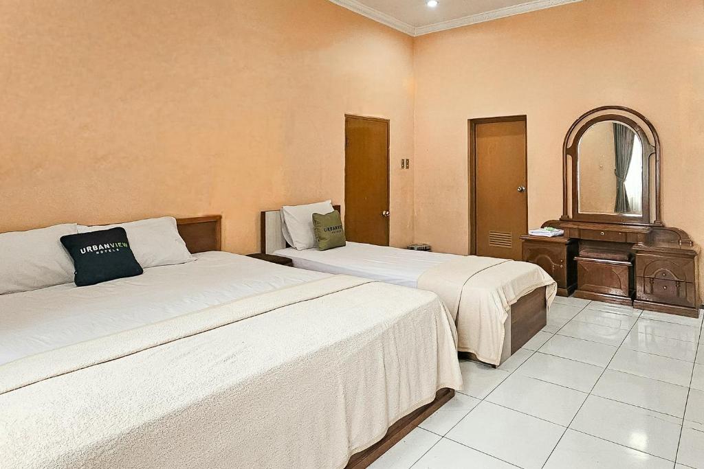 Postel nebo postele na pokoji v ubytování Urbanview My Grand Hotel Bogor