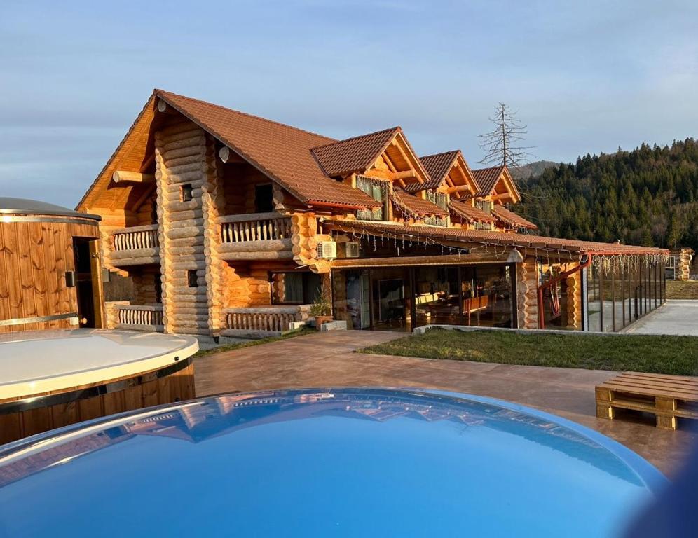 a log home with a pool in front of it at Chalet in Muntii Vrancei - Gresu - Lepsa cu Ciubar si Sauna in Greşu