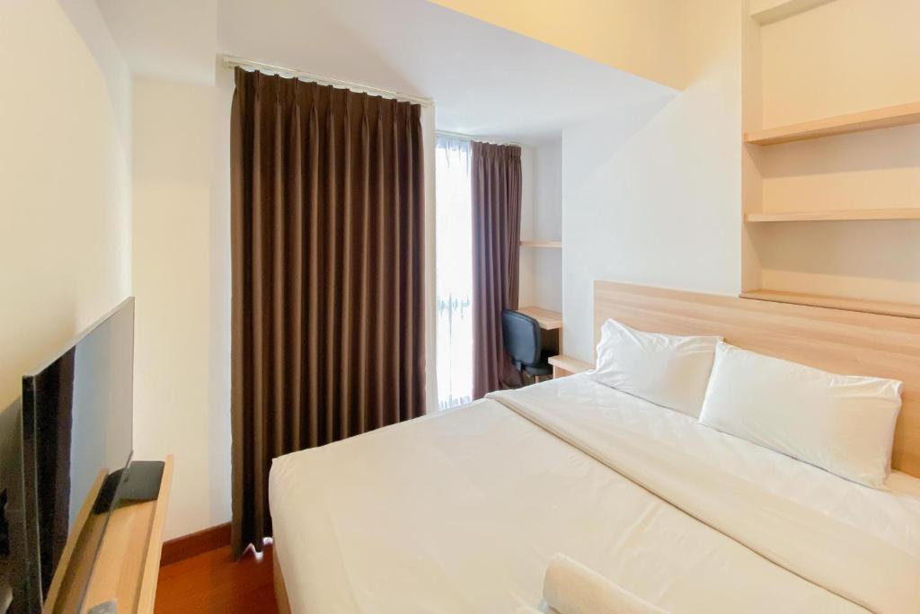 RawalembangModern Look Studio at Tokyo Riverside PIK 2 Apartment By Travelio的卧室里有一张白色的大床和一扇窗户