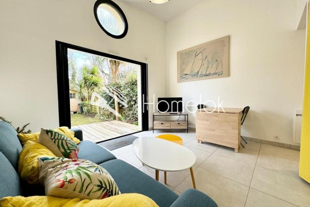 un salon avec un canapé bleu et une table dans l'établissement Maisonnette Hyper Cosy 200m du port de Lomener, à Ploemeur