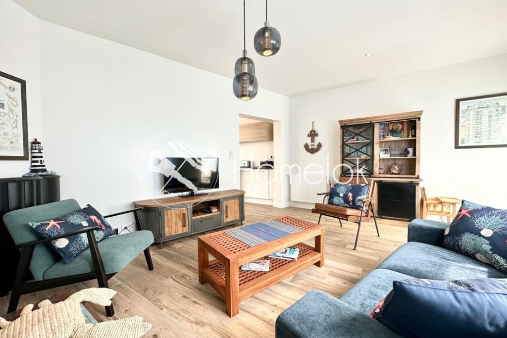 a living room with a couch and a table at Maison de pêcheur Rénovée À 50m des plages in Riantec