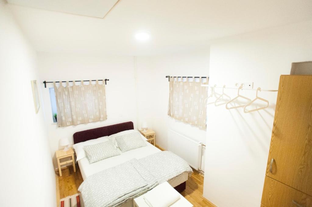 Dieses weiße Zimmer verfügt über 2 Betten und ein Fenster. in der Unterkunft Fifty Apartments in Zagreb