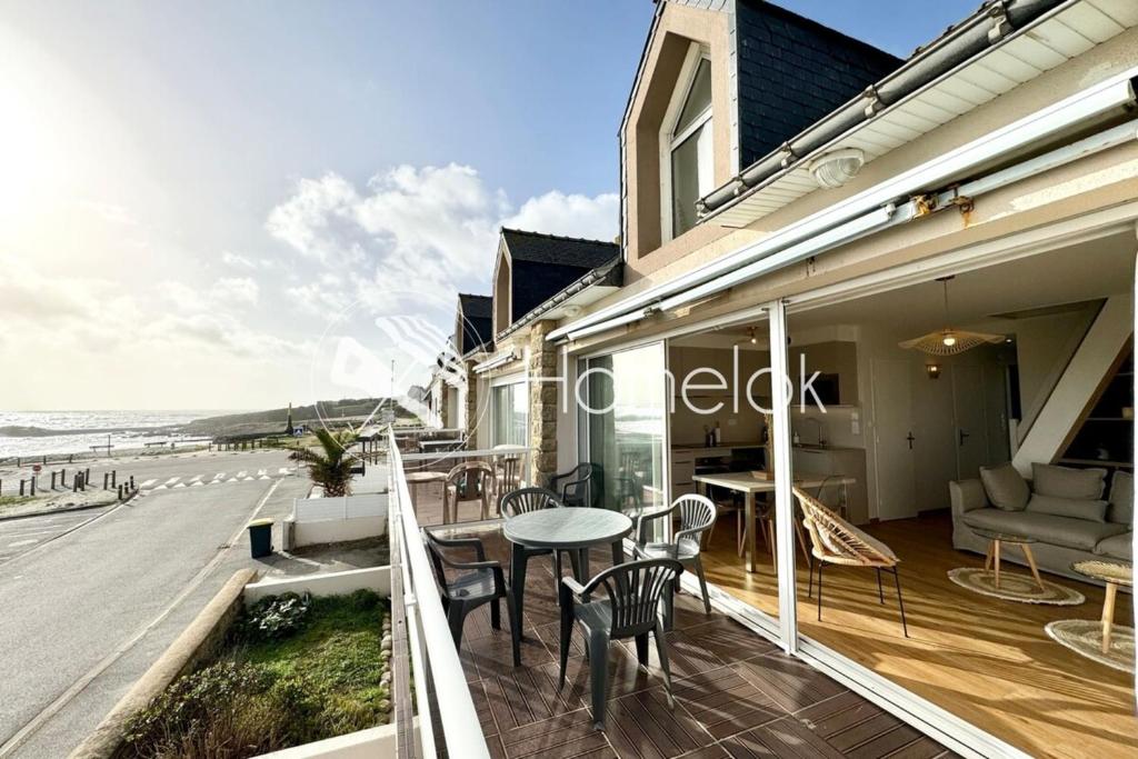 - un balcon avec une table et des chaises et la plage dans l'établissement Magnifique ! T3 les pieds dans l’eau vue mer, à Ploemeur