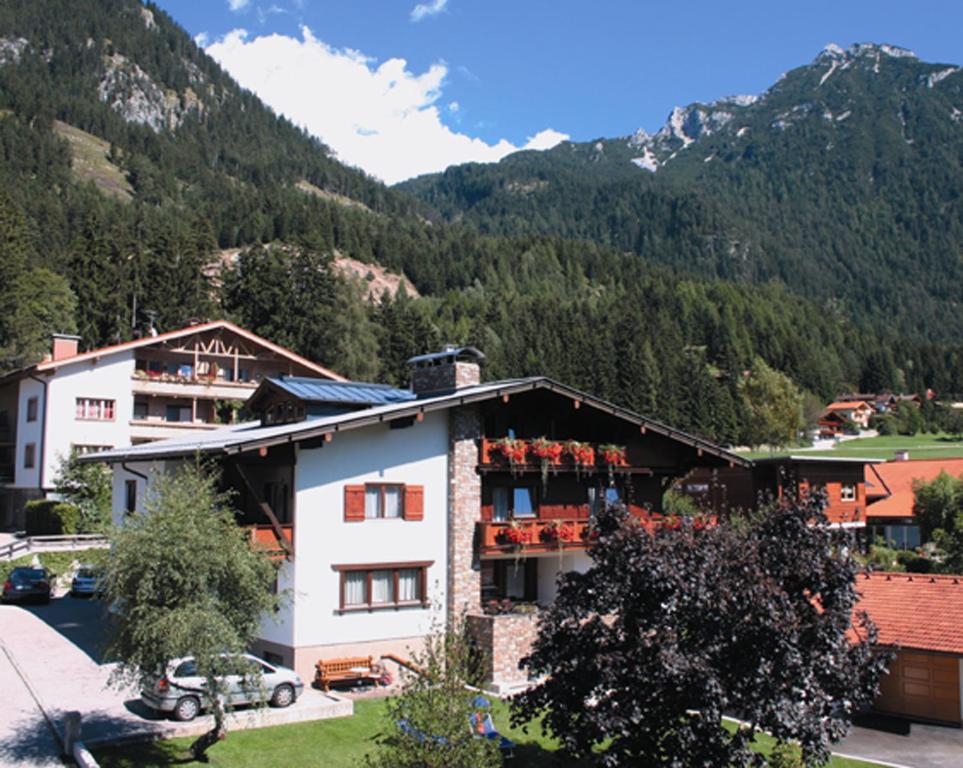 a hotel in the mountains with mountains in the background at Gästehaus Alpina in Maurach