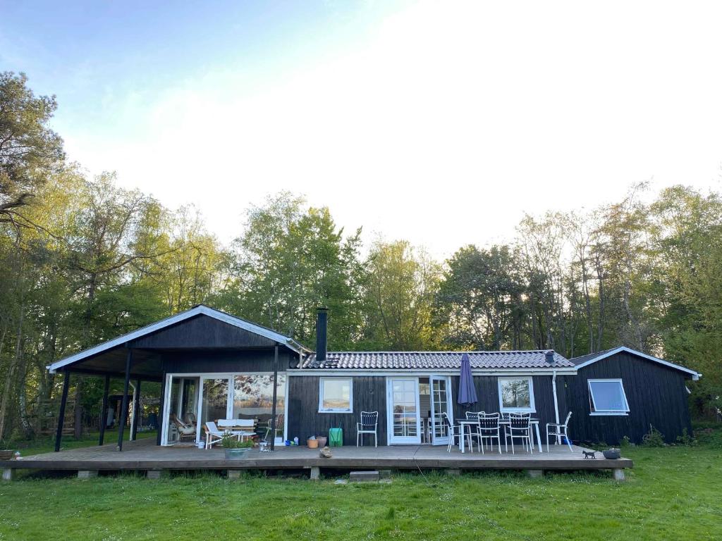 een klein huis met een veranda en een terras bij Unique, Artistic House With Fjord View in Holbæk