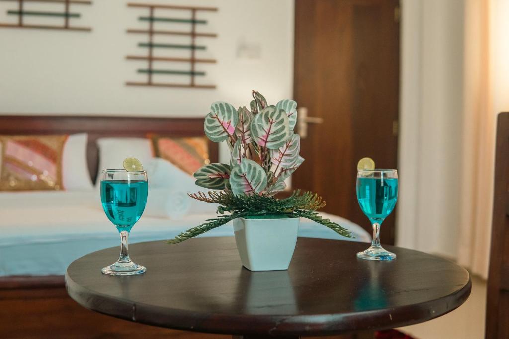 un tavolo con due bicchieri e una pianta in vaso di R2 Guest - HIKKADUWA a Hikkaduwa
