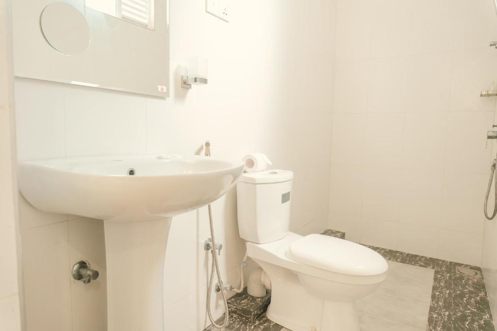 un bagno bianco con lavandino e WC di R2 Guest - HIKKADUWA a Hikkaduwa