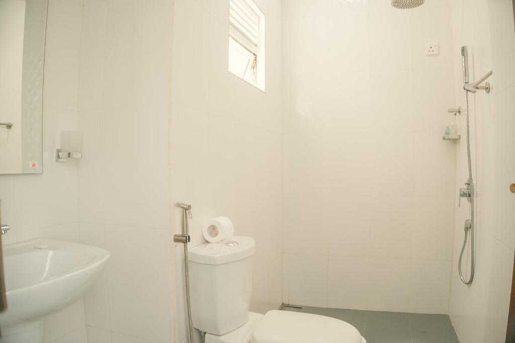 un bagno bianco con un water e un lavandino di R2 Guest - HIKKADUWA a Hikkaduwa