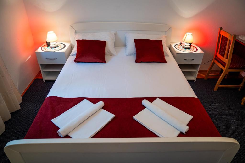 a bedroom with a large bed with red and white pillows at Guest House Cesic in Dubrovnik