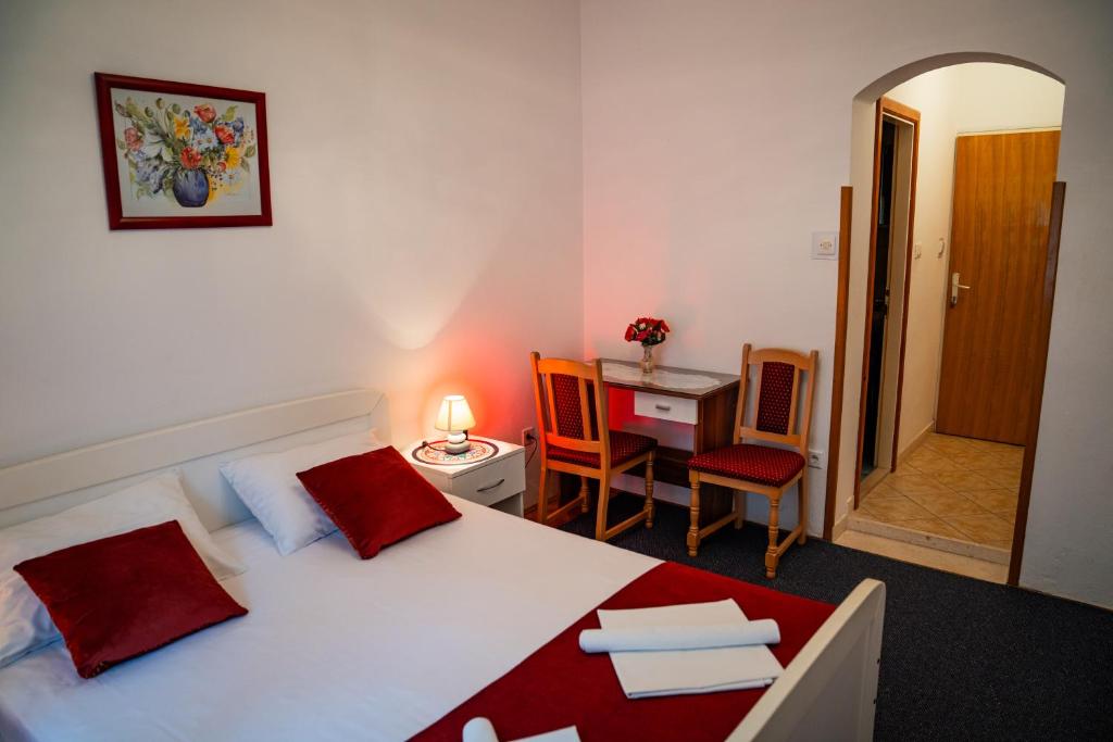 a bedroom with a bed and a desk and a table at Guest House Cesic in Dubrovnik