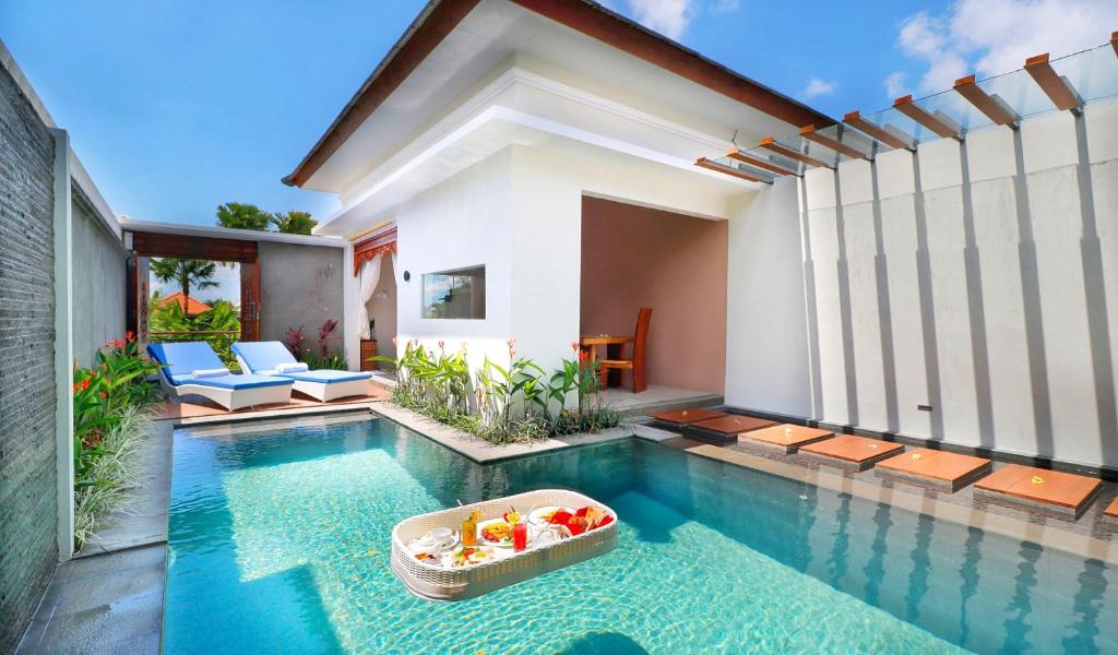 a pool with a bowl of fruit in the middle of a house at Maharaja Villas Seminyak by Humus Hospitality in Kerobokan