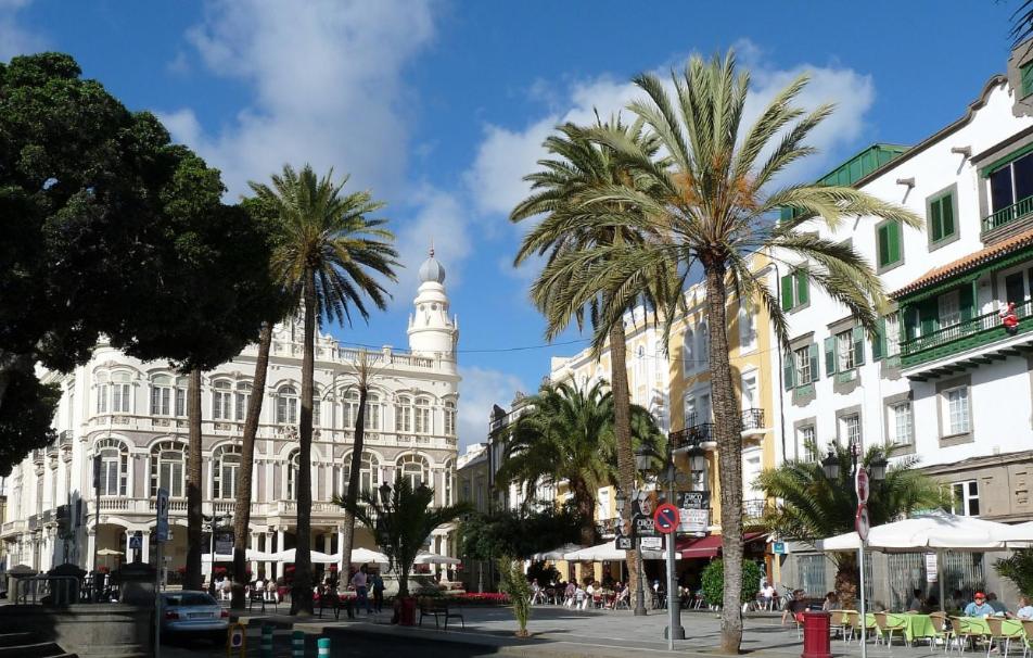 una calle con palmeras frente a un edificio en Hostel Las Palmas by Youroom, en Las Palmas de Gran Canaria
