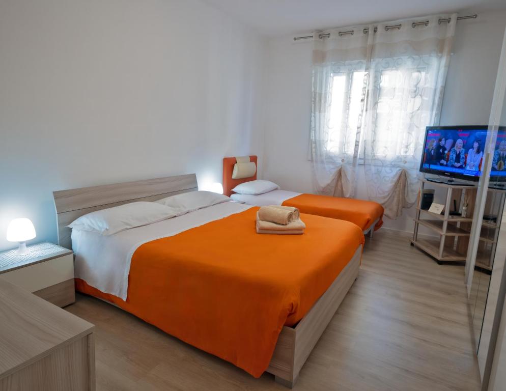 um quarto com duas camas e uma TV de tela plana em Home Istria 81 em Trieste