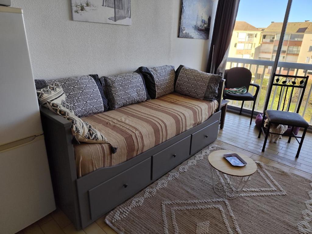 un canapé dans un salon avec une table dans l'établissement Chez Fleur, au Grau-du-Roi