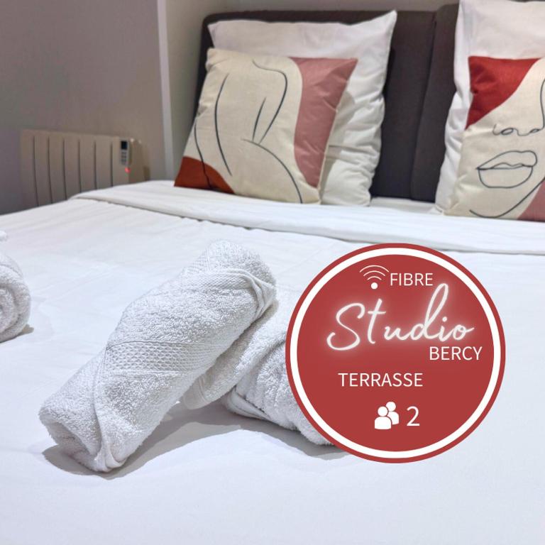 un panneau sur un lit avec des chaussettes blanches dans l'établissement Studio Bercy - Terrasse - Paris, à Paris